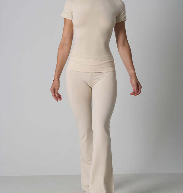 Casual Fit Cotton Jersey Yoga Set modeled by woman in cream short sleeve top and high-waist flare pants.
