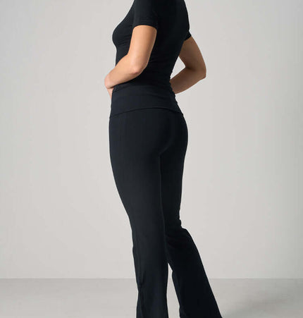 Casual Fit Cotton Jersey Yoga Set - Woman in stylish black crop top and high-waist flare pants, ideal for yoga and casual wear.