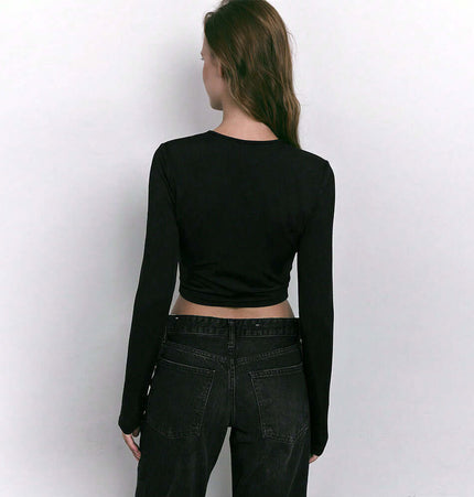 Back view of Collarless Long Sleeve Crop TShirt – Slim Fit in black, paired with high-waisted jeans.