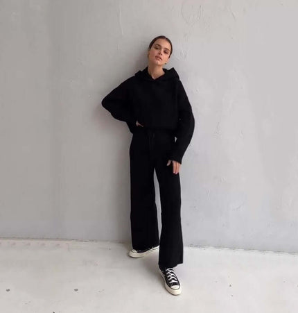 Model wearing a Cotton Blend Two-Piece Sports Set featuring a black hoodie and matching pants, in a minimalist setting.