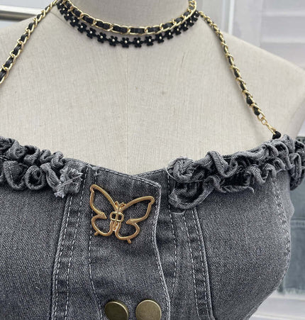 Close-up of the Denim Buckle Strapless Slim Fit Tank Top featuring ruffled neckline and butterfly detail.