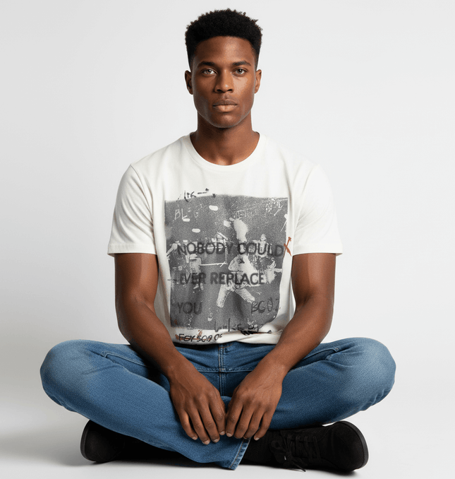 Creative Letter Print TShirt – Clean Fit featuring a fun letter print on a model sitting cross-legged.