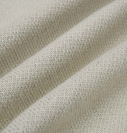 Close-up of soft fabric texture showcasing the knit of the Cross Jacquard Knit Sweater – Loose Fit.
