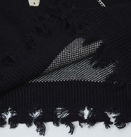Cross Jacquard Knit Sweater – Loose Fit showing frayed edges and distinctive texture in black fabric.