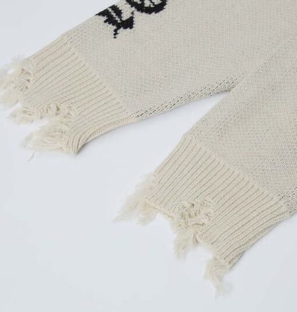 Cross Jacquard Knit Sweater – Loose Fit close-up of frayed sweater sleeves and knit texture.