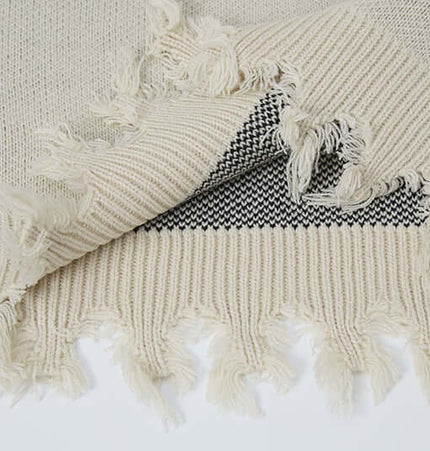 Close-up of the textured fabric of the Cross Jacquard Knit Sweater – Loose Fit, showcasing its soft acrylic blend.