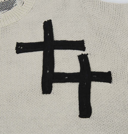 Close-up of Cross Jacquard Knit Sweater – Loose Fit highlighting the bold black jacquard design.