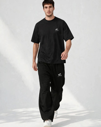 Walking shot showing the drape of the black wide-leg pants