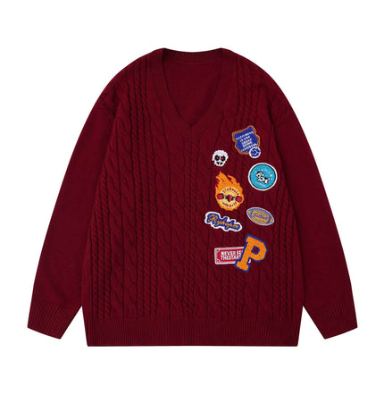 Embroidered Cable Knit VNeck Sweater with colorful patches on a red background, showcasing premium detailing and texture.