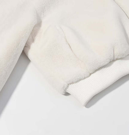 Detail of the sleeve of a Faux Fur Hooded Winter Coat in off-white fabric showing soft texture and ribbed cuff.