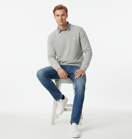Faux Layered Knit Sweater with Collar worn by a man sitting on a stool, showcasing a polished casual look.