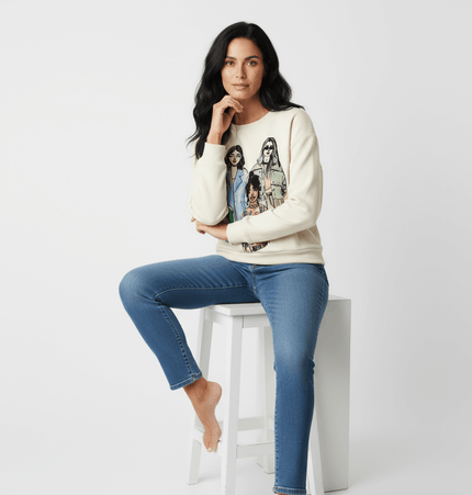 Girl Print Round Neck Sweatshirt worn by a model sitting on a stool, featuring a trendy printed girl pattern.