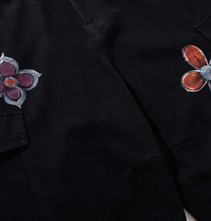 Graffiti Printed Cargo Denim Pants showcasing hand-painted flower details on a black background for bold street fashion.