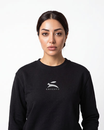 High-definition upper-body medium close-up zoom of model Sienna wearing GROZAVU Black Crewneck Sweatshirt showcasing chest artwork and natural skin