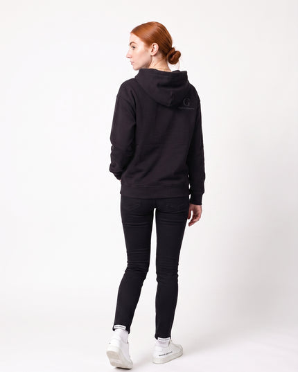 Full body rear view of model Sienna wearing GROZAVU Black Hoodie showcasing rear garment structure and back artwork