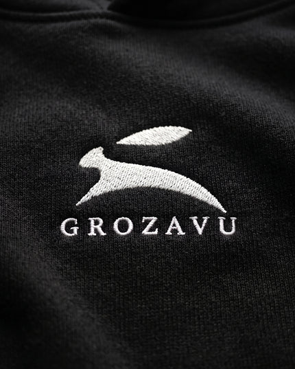 Extreme macro close-up of GROZAVU Black Hoodie showcasing premium heavyweight fabric weave, tactile ribbing, and razor-sharp graphic print detail
