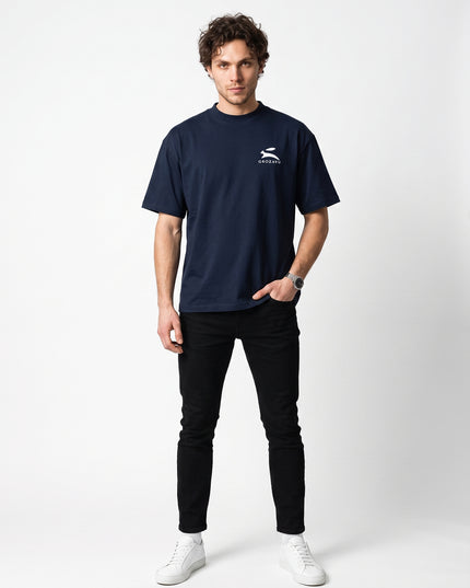 Straight-on front full-body view of model Jax wearing GROZAVU Dark Navy T-Shirt in seamless white studio