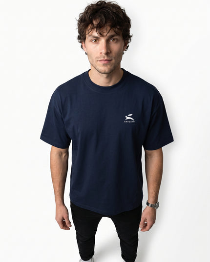High-definition upper-body medium close-up zoom of model Jax wearing GROZAVU Dark Navy T-Shirt showcasing chest artwork and natural skin