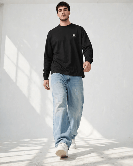 Low-angle walking shot of the black heavyweight long sleeve tee