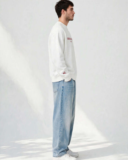 Side profile of the white oversized crewneck showing the dropped shoulder
