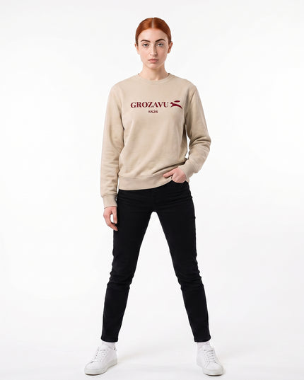 Straight-on front full-body view of model Sienna wearing GROZAVU SS26 Beige Crewneck Sweatshirt in seamless white studio