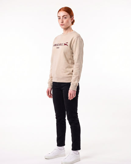 Editorial left-side profile view of model Sienna wearing GROZAVU SS26 Beige Crewneck Sweatshirt highlighting left side silhouette, sleeve drape, and natural facial profile