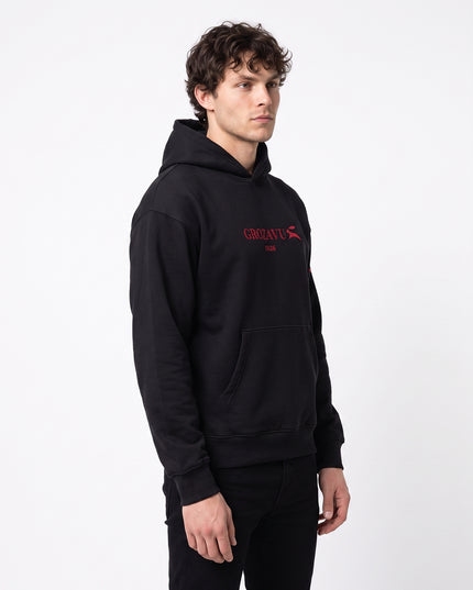 Front full-body fashion lookbook of GROZAVU SS26 Black Hoodie worn by model Jax