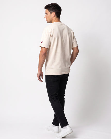 Full body rear streetwear lookbook of GROZAVU SS26 Cream T-Shirt showcasing back artwork worn by model Lucas