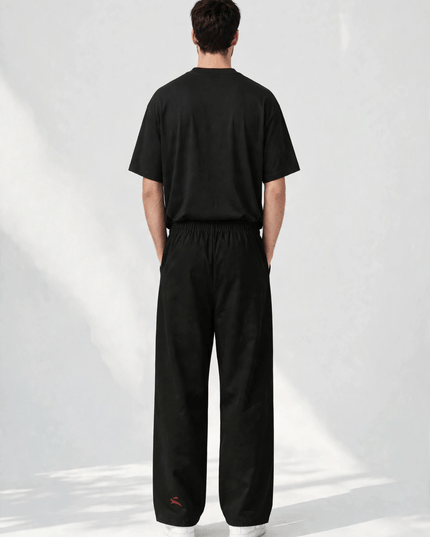 Back view of the SS26 wide-leg pants with the deep red mark