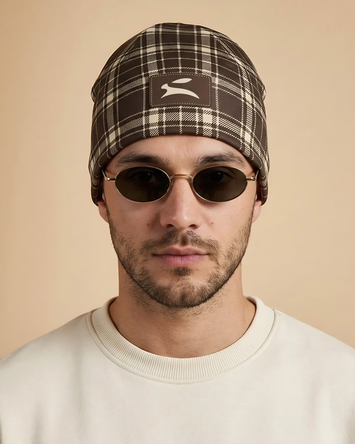 Model wearing the Heritage Tartan Beanie in Cocoa, front view with the Grozavu hare patch