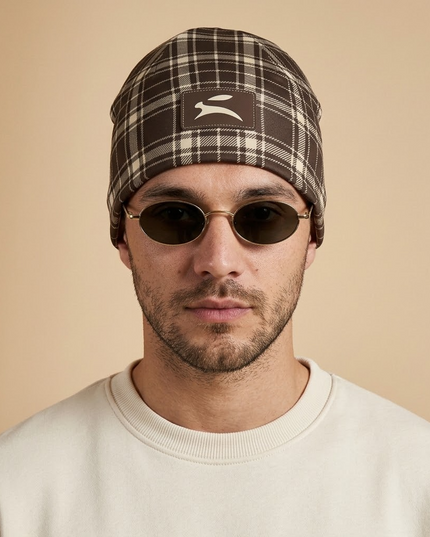 Model wearing the Heritage Tartan Beanie in Cocoa, front view with the Grozavu hare patch