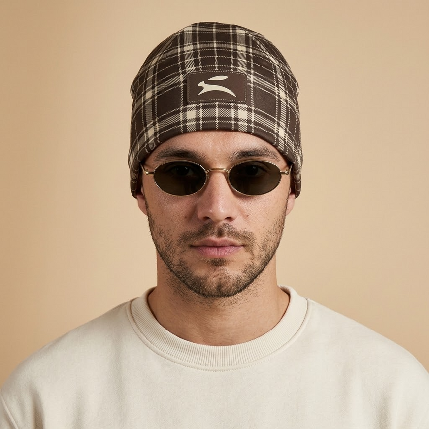 Model wearing the Heritage Tartan Beanie in Cocoa, front view with the Grozavu hare patch