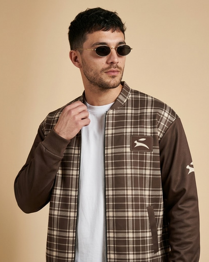Close-up of the Grozavu hare patch on the Heritage Tartan Bomber in Cocoa, worn by the model