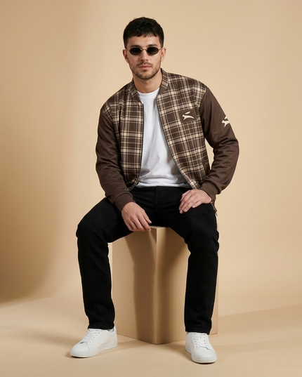Model seated in the studio wearing the Heritage Tartan Bomber in Cocoa open