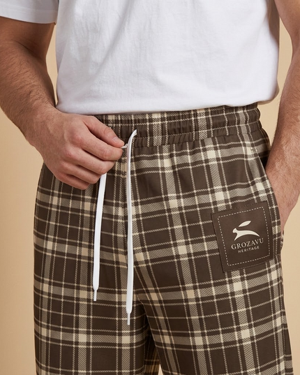 Close-up of the drawstring waist and the printed Grozavu Heritage label on the Heritage Tartan Wide-Leg Joggers in Cocoa