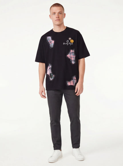 Model wearing Black applique badge graphic tee by Grozavu