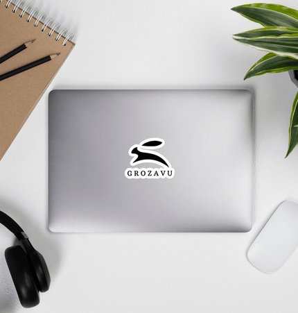 Kiss-cut vinyl decals on a laptop surrounded by office supplies and a plant.