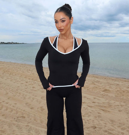 Model wearing Long Sleeve Halter Neck Contrast Top by the beach, showcasing its sleek design and modern style.