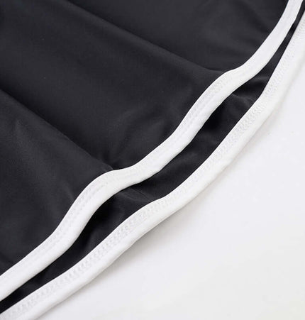 Long Sleeve Halter Neck Contrast Top fabric close-up featuring black material with white trim.