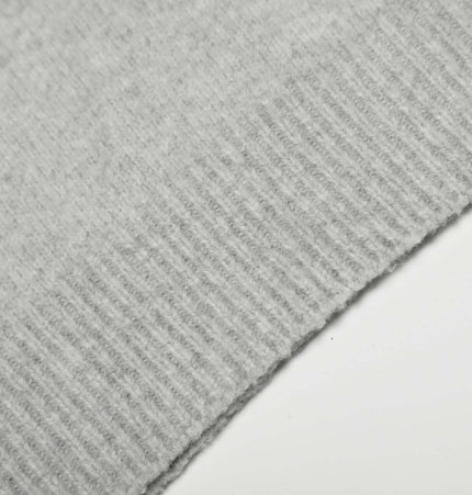 Loose Buttoned Turn Down Collar Sweater close-up texture of soft polyester knit fabric in light gray.