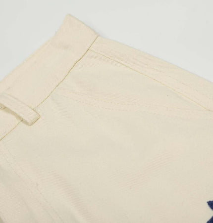 Loose Fit Cartoon Patchwork Pants detail showcasing cartoon embroidery and button closure.