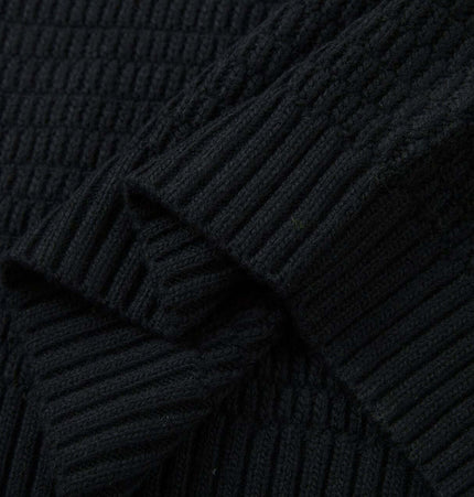 Loose Fit Plain Knit Sweater close-up showing textured knit pattern and ribbed sleeves in black fabric.
