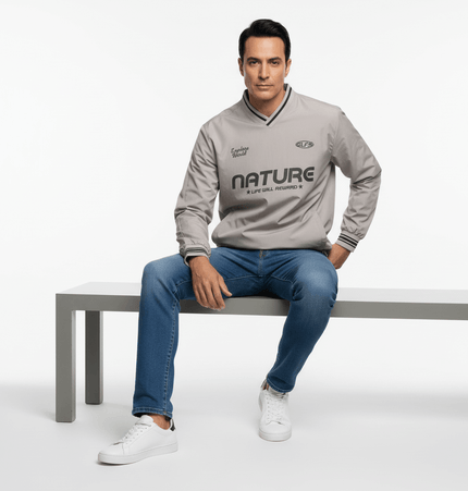 Man sitting on a bench wearing a gray Nature jacket, showcasing outdoor style and comfort.