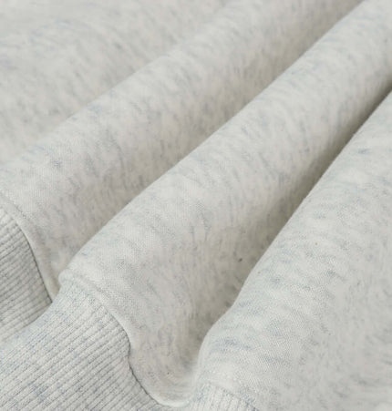 Close-up of the fabric texture of an Oversized Hooded Sweatshirt – Loose Fit in a soft light gray color.