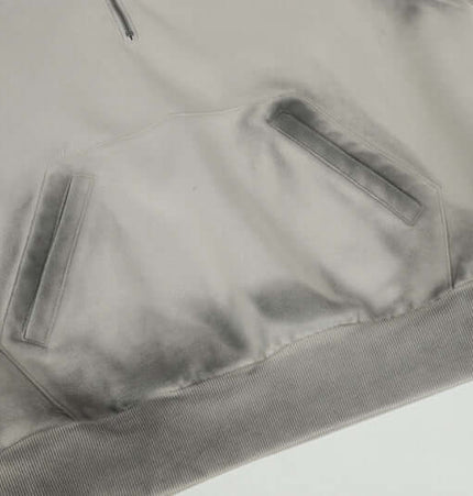 Close-up of the Patchwork Half-Zip Hoodie showing the unique fabric texture and pocket details.