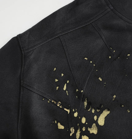 Splashing Ink Spliced Hooded Sweatshirt featuring a bold black design with gold splashes for artistic streetwear.