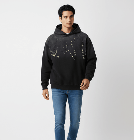 Man wearing a Splashing Ink Spliced Hooded Sweatshirt with a unique splashing ink design.