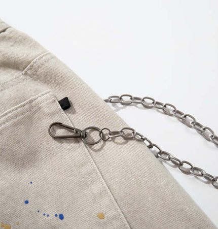 Close-up of the pocket detail and chain accessory on Straight Leg Patchwork Denim Jeans.