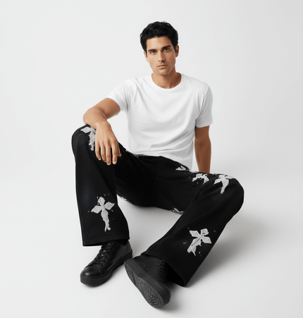 Model wearing Straight Leg Patchwork Denim Jeans with cross patch embroidery and color splatter details.