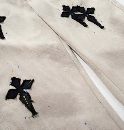Straight Leg Patchwork Denim Jeans featuring cross patch embroidery and color splatter detailing.